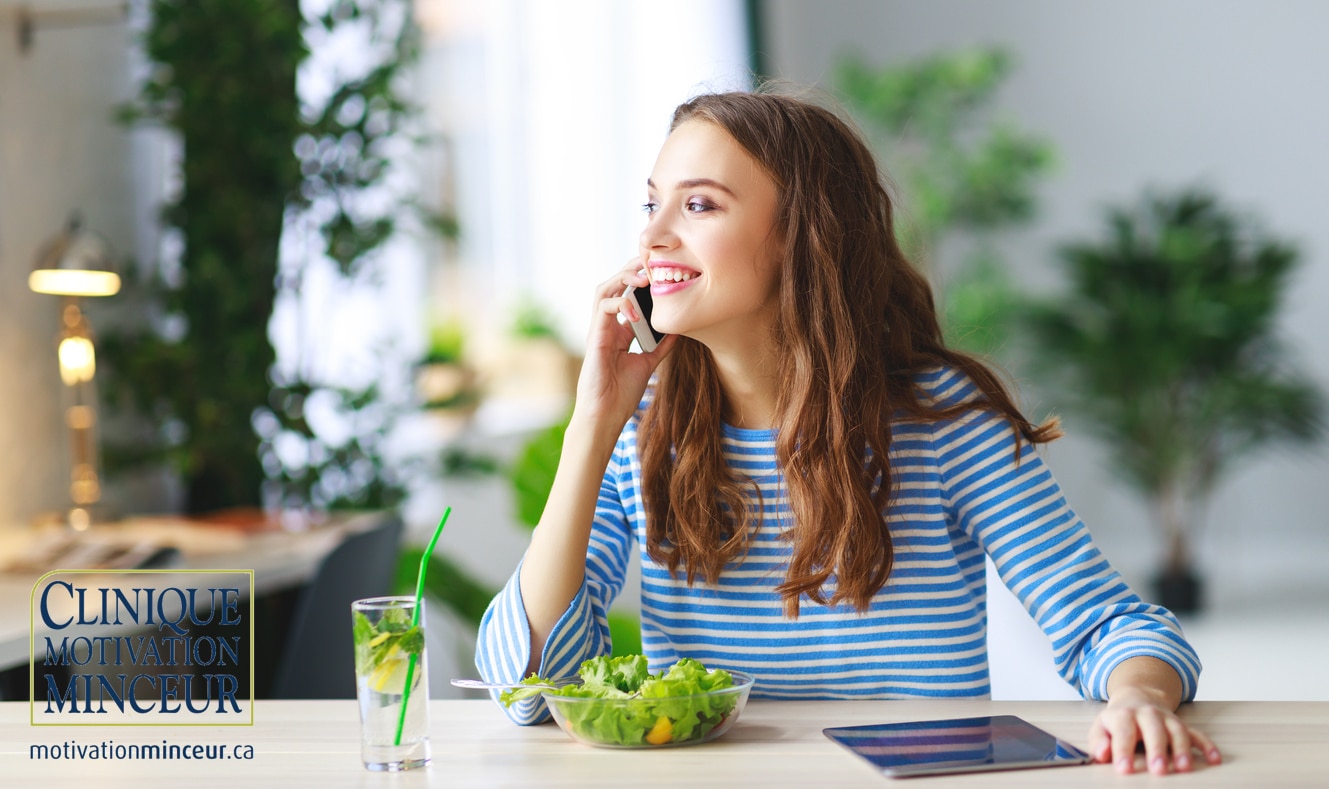 healthy eating. happy young girl eating salad with tablet pc in morning in kitchen