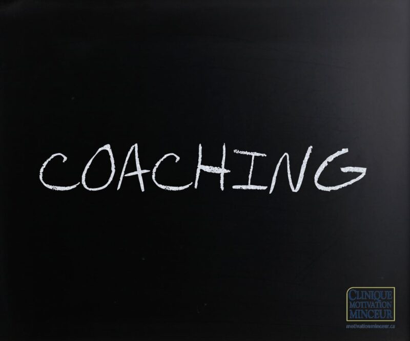 "Coaching" handwritten with white chalk on a blackboard