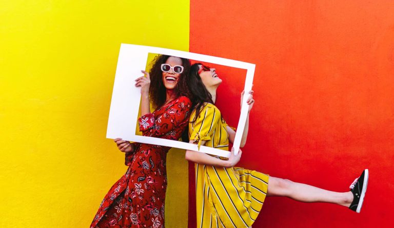 Smiling women with empty photo frame
